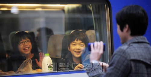 20일 오전 서울역을 찾은 한 시민이 짧은 연휴 탓으로 아내와 애들만 먼저 고향으로 보내면서 인사를 나누고 있다. 박해묵 기자/mook@heraldm.com\r\n20일 오전 서울역을 찾은 한 시민이 짧은 연휴 탓으로 아내와 애들만 먼저 고향으로 보내면서 인사를 나누고 있다. 박해묵 기자/mook@heraldm.com\r\nKTX 유리창 사이로 부자(父子)의 정(情)이 오간다. 아빠는 일 때문에 고향집에 늦게 내려가야 하고, 아내와 아들은 하루 먼저 간다. 손을 흔드는 그들. 유리창 너머로 “아빠 빨리 오셔야 해요”라는 아들의 목소리에 아빠는 힘이 난다. 20일 오전 서울역에서 아내와 아들을 먼저 고향집으로 보내는 한 직장인 아빠의 뒷모습이 아쉬워 보인다. 	 박해묵 기자/mook@heraldm.com