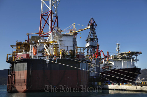 The Pazflor floating production, storage and offloading facility (left) and a drill ship ordered by a Brazilian company are moored at the Daewoo Shipbuilding & Marine Engineering Co. shipyard in Geoje, South Gyeongsang Province.  Bloomberg