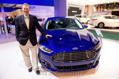 Alan Mulally, CEO of Ford Motor Co., stands for a photograph with a 2013 Ford Fusion car at the International Consumer Electronics Show in Las Vegas.  Bloomberg