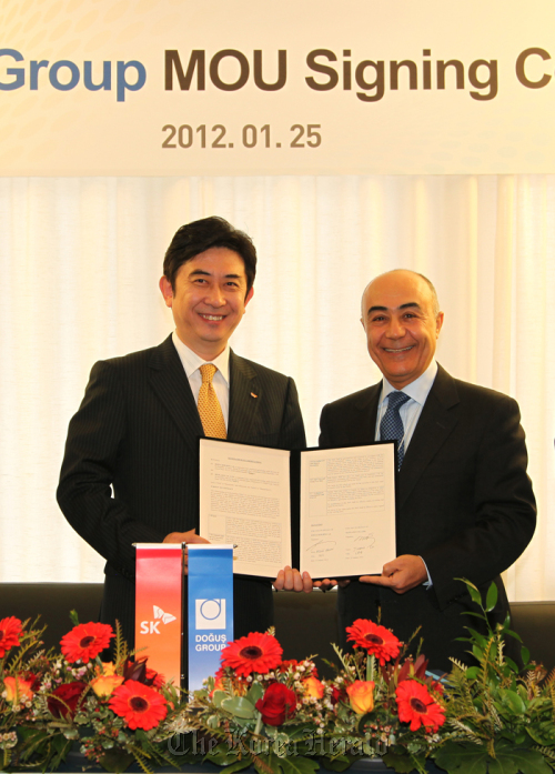 SK Planet CEO Seo Jin-woo (left) and Dogus Grubu CEO Husnu Akhan stand with a memorandum of understanding at Holland House, a mountain resort in Davos, Switzerland, Wednesday.
SK Planet