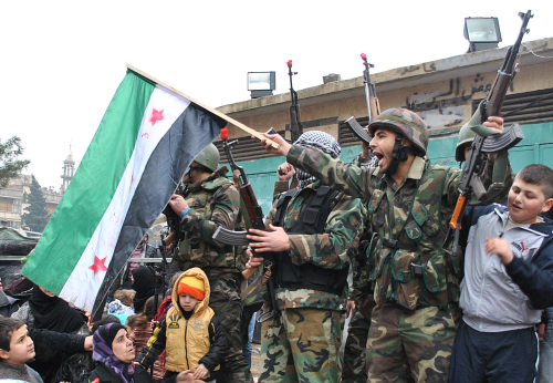 <YONHAP PHOTO-0419> A Syrian army defector, waves the Syrian revolution flag and shouts slogans shortly after he defected with other soldiers and join the anti-Syrian regime protesters at Khalidiya area in Homs province, central Syria, on Thursday, Jan. 26, 2012. Syrian troops stormed a flashpoint suburb of Damascus on Thursday, rounding people up in house-to-house raids and clashing with army defectors, activists said, as the 10-month-old uprising inches ever closer to the capital. (AP Photo)/2012-01-27 09:35:19/ <저작권자 ⓒ 1980-2012 ㈜연합뉴스. 무단 전재 재배포 금지.>
Syrian army defectors shout shortly after joining anti-regime protesters in Homs province on Thursday. AP-Yonhap News