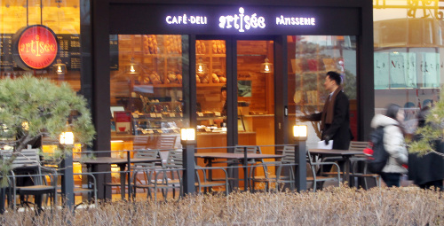 Pedestrians pass by Hotel Shilla-affiliated bakery cafe Artisee in downtown Seoul on Thursday. (Yonhap News)