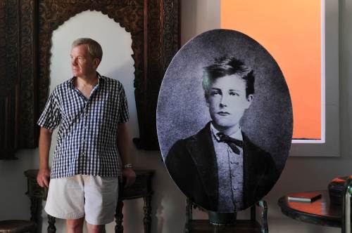 <YONHAP PHOTO-0828> TO GO WITH AFP STORY "FRANCE-INDONESIA-LITERATURE-RIMBAUD" BY LOIC VENNIN In this file photograph taken on November 14, 2011 shows US author Jamie James standing beside a portrait of famous French poet Arthur Rimbaud (1854-1891), in his shop in Kerobokan in the Indonesian island of Bali. James is attempting to uncover the mystery of Rimbauds escape in the island of Java in his book "Rimbaud in Java, the lost voyage" published by Editions Didier Millet. Rimbaud embarked on a journey to Java at the age of 21 after conscripting to serve in the Dutch colonial army. Arriving in Batavia on July 22, 1876 Rimbaud and hundreds of Dutch troops were transported by train to Tuntang and stationed in Salatiga garrison where he deserted after two weeks. AFP PHOTO / ROMEO GACAD /2012-01-28 12:04:10/ <저작권자 ⓒ 1980-2012 ㈜연합뉴스. 무단 전재 재배포 금지.>
U.S. author Jamie James stands beside a portrait of famous French poet Arthur Rimbaud in his shop in Kerobokan, Indonesia, on Nov. 14.  AFP-Yonhap News