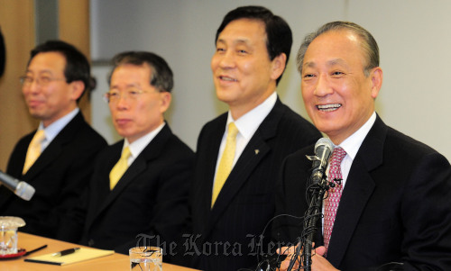 Hana Financial Group chairman Kim Seung-yu (right) smiles during a news conference on Friday.  Yonhap News
