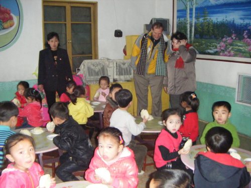 SHARING PAGE
Shirley VanderSchaaf and Robert Brownell watch children eating bread made at a Love North Korean Children bakery in Rajin, North Korea. LNKC