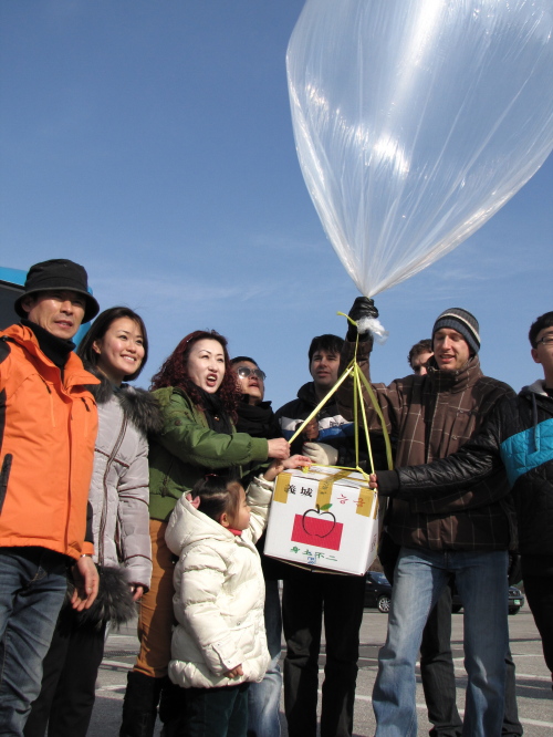 SHARING PAGE
North Korean defector Lee Ju-seong (left) and international volunteers prepare to launch aid balloons in Paju on Saturday.  Kirsty Taylor/The Korea Herald