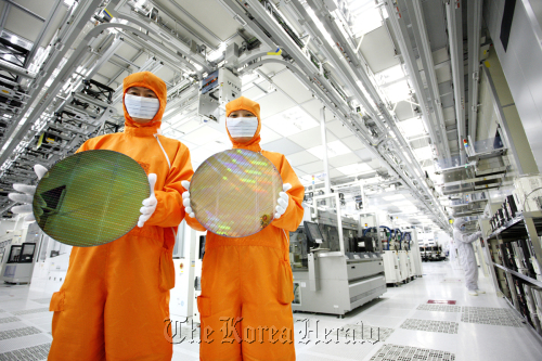 Workers are seen at the Hynix Semiconductor production line.  Hynix
Workers are seen at the Hynix Semiconductor production line.  Hynix