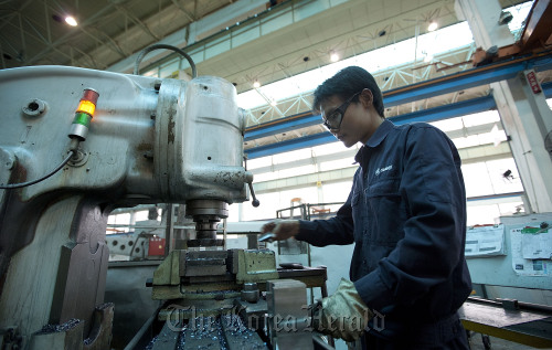 A Sany Heavy Industry Co. worker machines parts at the factory in Changsha, Hunan Province, China.  Bloomberg