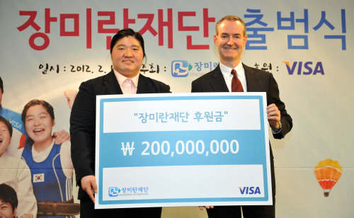 <YONHAP PHOTO-0766> 장미란 재단 출범식 (서울=연합뉴스) 최재구 기자 = 역도 국가대표 장미란 선수가 1일 서울 중구 프레스센터에서 열린 '장미란 재단 출범식'에서 제임스 딕슨 비자코리아 사장으로부터 후원금을 전달 받고 기념촬영을 하고 있다. 재단은 앞으로 공식 후원을 맡은 비자코리아와 함께 재정지원을 요구하는 올림픽 비인기 종목에 힘을 보태는 등 장학사업 및 소외계층 꿈나무 육성을 위한 교육 프로그램 운영 등 스포츠 멘토링 프로그램과 운동선수들을 위한 의료 지원사업도 병행할 예정이다. 2012.2.1 jjaeck9@yna.co.kr/2012-02-01 13:14:40/ <저작권자 ⓒ 1980-2012 ㈜연합뉴스. 무단 전재 재배포 금지.>
Weightlifter Jang Mi-ran poses with Visa Korea president James Dixon after receiving 200 million won for the Jang Mi-ran Foundation in Seoul on Wednesday.  Yonhap News