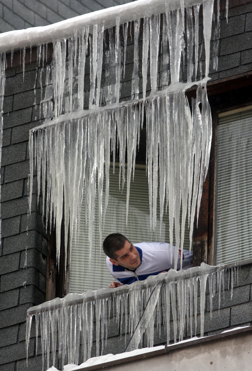 <YONHAP PHOTO-0032> A man views icicles on a window in Uzice 200 kilometers (125 miles) southwest of Belgrade, Serbia, Thursday, Feb. 2, 2012. At least 11,000 villagers have been trapped by heavy snow and blizzards in Serbia's mountains, authorities announced Thursday, as the death toll from Eastern Europe's weeklong deep freeze rose to 122. .(AP Photo)/2012-02-03 00:58:30/ <저작권자 ⓒ 1980-2012 ㈜연합뉴스. 무단 전재 재배포 금지.>
A man views icicles on a window in Uzice, 200 kilometers southwest of Belgrade, Serbia, Thursday.  AP-Yonhap News