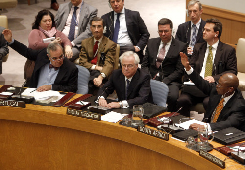 Portuguese representative Jose Filipe Moraes Cabral (left) and South African representative Baso Sangqu (right) glance at Russian representative Vitaly Churkin (center) as they vote in support of a draft resolution backing an Arab League call for Syrian President Bashar Assad to step down, which was later vetoed by Russia and China, during a meeting of the United Nations Security Council at United Nations headquarters on Saturday. (AP-Yonhap News)