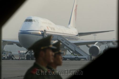 Members of China’s paramilitary police stand in front of an Air China Ltd. airplane at Beijing Capital International Airport.  Bloomberg