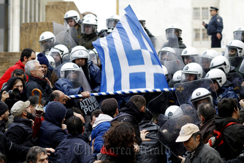 Riot policemen clash with protesters trying to reach the entrance of the Greek Parliament building during a 24-hour general strike in Athens on Tuesday.  Bloomberg