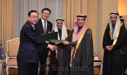 S-Oil executive vice president Kim Dong-cheoul (left) exchanges a 20-year crude supply contract with Saudi Aramco senior vice president Khalid Al-Buainain (second from right) on Wednesday in Riyadh in the presence of Knowledge Economy Minister Hong Suk-woo (second from left), Saudi Arabian Petroleum and Mineral Resources Minister Ali al-Naimi (third from left) and Saudi Aramco chief executive Khalid Al-Falih (right). S-Oil
S-Oil executive vice president Kim Dong-cheoul (left) exchanges a 20-year crude supply contract with Saudi Aramco senior vice president Khalid Al-Buainain (second from right) on Wednesday in Riyadh in the presence of Knowledge Economy Minister Hong Suk-woo (second from left), Saudi Arabian Petroleum and Mineral Resources Minister Ali al-Naimi (third from left) and Saudi Aramco chief executive Khalid Al-Falih (right). S-Oil