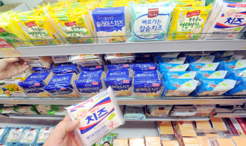 A consumer grabs a cheese product at a supermarket in Seoul. (Ahn Hoon/The Korea Herald)