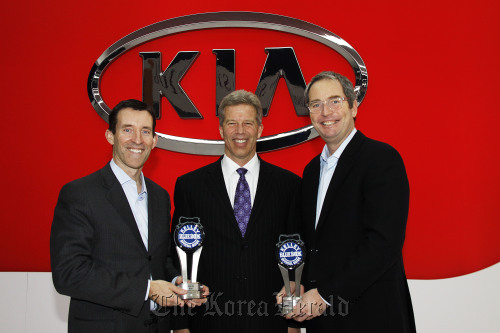 Michael Sprague (left), vice president at Kia Motors America, poses with Vincent D. Nelson (center), executive vice president of Analytic Insights for Kelley Blue Book, and a KMA executive after an awarding ceremony in Chicago on Wednesday.  Kia Motors