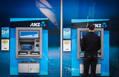 A customer uses an automated teller machine outside an Australia & New Zealand Banking Group Ltd. branch in Sydney.  Bloomberg