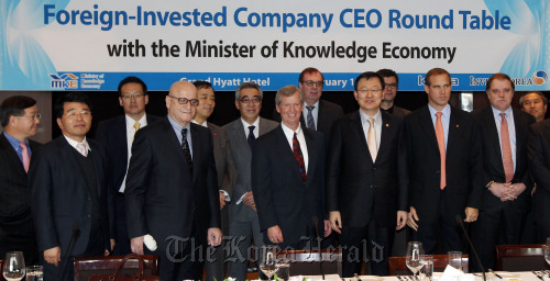 Knowledge Economy Minister Hong Suk-woo (third from right) and chief executives of foreign-invested firms pose for a photo before a discussion on ways to support the companies’ investment Monday at a Seoul hotel. Yonhap News