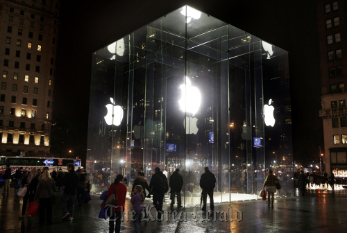 Shoppers walk near the entrance to the Apple Inc. store on Fifth Avenue in Manhattan, New York.  Bloomberg