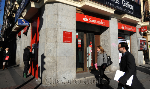 Pedestrians pass a Banco Santander SA branch in Madrid.  Bloomberg