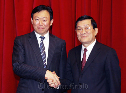 Lotte Group chairman Shin Dong-bin (left) shakes hands with Vietnamese President Truong Tan Sang in a meeting at the Presidential Palace in Hanoi on Monday.  Lotte Group