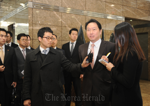 SK Group chairman Chey Tae-won (second from right) takes questions from reporters as he enters the Hynix building in southern Seoul to attend a board meeting where he was appointed co-CEO of the chipmaker on Tuesday.      Hynix