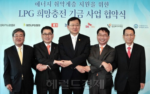 LPG업계및 한국에너지재단은 15일 명동 포스트타워에서 홍석우 지식경제부장관이 참석한 가운데 1백억원 규모로 사회공헌기금을 조성,에너지 취약계층 지원을 위한 'LPG 희망충전기금' 사업협약식을 가졌다. 좌로부터 고윤화 대한LPG협회장,구자용 E1회장,홍석우 지식경제부장관,정헌 SK가스사장, 김기춘 한국에너지재단이사장.<br />정희조 기자/checho@heraldm.com 120215
Knowledge Economy Minister Hong Suk-woo (center) holds hands with representatives from LPG-related public and private agencies at a donation ceremony in Seoul on Wednesday.     Chung Hee-cho/The Korea Herald