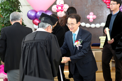 삼성코닝정밀소재 이헌식 사장이 노숙인 인문학과정 졸업생들에게 선물을 전달하고 있다.