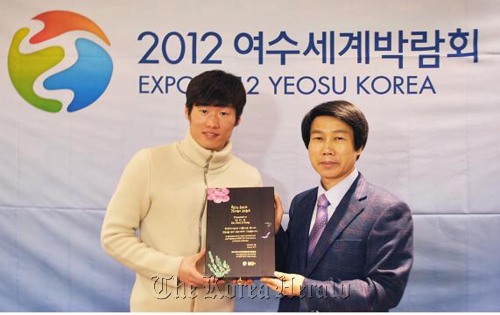 Footballer Park Ji-sung (left) receives a plaque from a Yeosu Expo organizing committee official after being named the goodwill ambassador for the Expo on Wednesday.   Yeosu Expo Organizing Committee