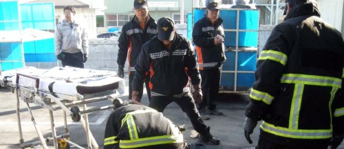 Emergency service members look at a dead body after a shooting spree at a factory in South Chungcheong Province Wednesday. (Yonhap News)