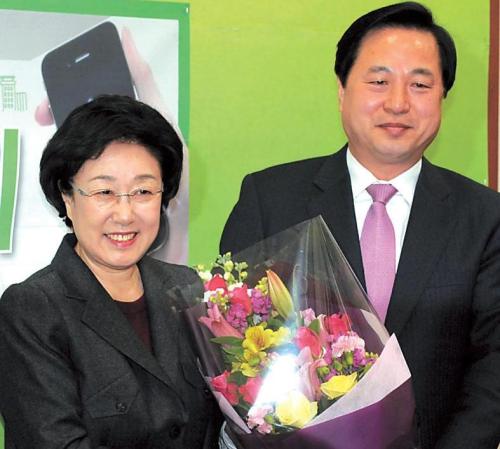 The main opposition Democratic United Party leader Han Myeong-sook (left) welcomes South Gyeongsang Gov. Kim Doo-kwan to the party on Thursday. (Ahn Hoon/The Korea Herald)