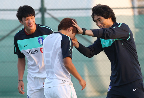 <YONHAP PHOTO-0009> 김태형 코치, '강하게 키워야지' (무스카트<오만>=연합뉴스) 박지호 기자 = 2012 런던올림픽 아시아 지역 최종예선 오만전을 사흘 앞둔 축구대표팀 선수들이 19일 오후(현지시간) 오만 무스카트 공항을 통해 입국했다. 이날 저녁 무스카트 시내 술탄 카부스 스타디움에서 열린 첫 훈련에서 김태형 코치가 훈련 도중 한 선수의 이마를 손가락으로 때리며 장난을 치고 있다. 2012.2.19 jihopark@yna.co.kr/2012-02-20 00:25:18/ <저작권자 ⓒ 1980-2012 ㈜연합뉴스. 무단 전재 재배포 금지.>
Korea’s U23 assistant coach Kim Tae-young jokes with players during the team’s first practice in Oman on Sunday.  Yonhap News