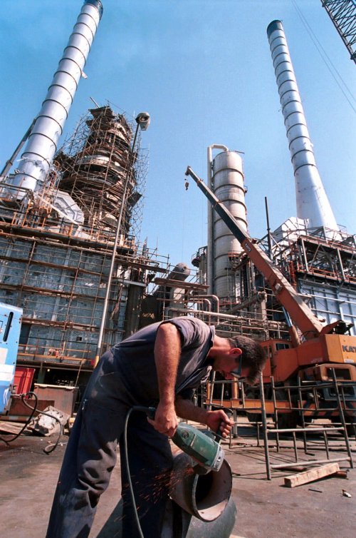 In this Sept. 27, 2000 file photo, an Iranian oil worker repairs a pipe at an oil refinery in Tehran. Iran has halted oil shipments to Britain and France, the Oil Ministry said Sunday, in an apparent pre-emptive blow against the European Union after the bloc imposed sanctions on Iran's crucial fuel exports. (AP-Yonhap News)