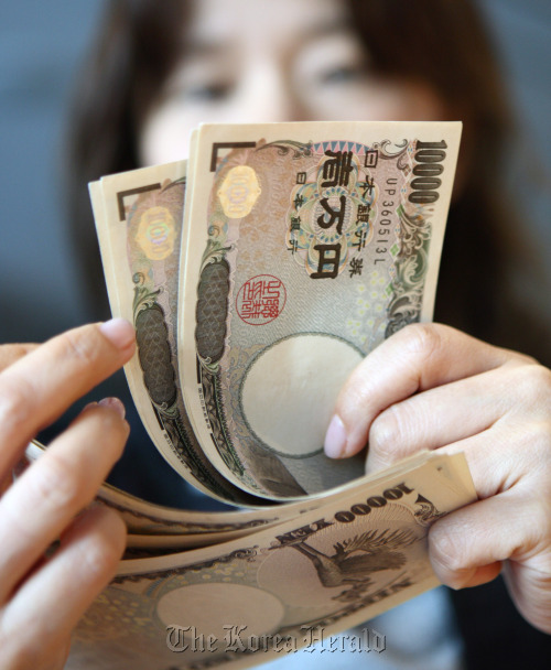 A woman arranges Japanese 10,000 yen notes for a photograph in Tokyo.  Bloomberg