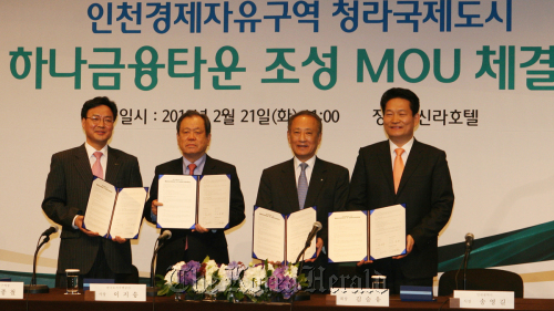Hana Financial Group chairman Kim Seung-yu (second from right) and Incheon Mayor Song Young-gil (right) pose after signing a pact to set up the “Hana Financial Town” at the Cheongna district of the Incheon Free Economic Zone at a hotel in Seoul on Tuesday.   Hana Financial