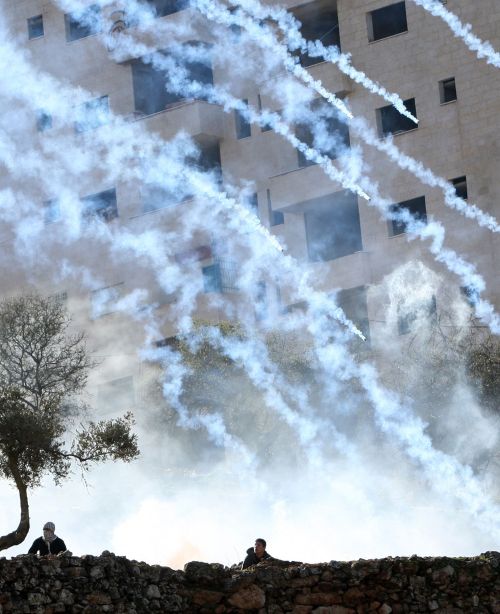 <YONHAP PHOTO-0641> Palestinian protester take cover as Israeli troops firing tear gas during a demonstration outside the entrance of Ofer Prison near Ramallah in the occupied West Bank in support of a fellow prisoner who has ended on February 21, 2012 a 66-day hunger strike over his detention without charge under a deal that will see him released in April. Khader Adnan, 33, was arrested on December 17 and began refusing food a day later to protest his detention without charge and his alleged mistreatment by interrogators. TOPSHOTS/AFP PHOTO/ABBAS MOMANI../2012-02-22 09:16:37/ <저작권자 ⓒ 1980-2012 ㈜연합뉴스. 무단 전재 재배포 금지.>
Palestinian protesters take cover as Israeli troops fire tear gas during a demonstration outside the entrance of Ofer Prison near Ramallah in West Bank.
