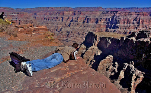 A visitor looks over the edge at the West Rim of the Grand Canyon.  Los Angeles Times/MCT