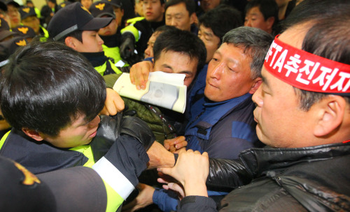 <YONHAP PHOTO-0918> 아비규환 '한중 FTA 공청회' (서울=연합뉴스) 이상학 기자 = 한중 자유무역협정(FTA) 협상을 위한 첫 공식절차인 '한중 FTA 공청회'가 24일 오전 삼성동 코엑스컨벤션센터에서 열렸다. FTA 협상에 반대하는 한국농업경영인중앙연합회 회원 등이 공청회장에서 행사 중단을 요구하며 몸싸움을 하고 있다. 2012.2.24 leesh@yna.co.kr/2012-02-24 12:30:51/ <저작권자 ⓒ 1980-2012 ㈜연합뉴스. 무단 전재 재배포 금지.>
Protesters resist as the police try to remove them from the venue of the public hearing on the Korea-China FTA in Seoul on Friday.
Yonhap News