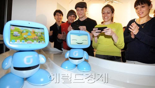 27일 스페인 바르셀로나에서 개막하는 모바일월드콩그레스(MWC) KT 부스에서 전시회 참가자들이 스마트폰으로 키봇을 조정해 경주를 하고 있다. KT는 이번 전시회에서 글로벌 통신사인 미국 at&t, 영국 보다폰과 함께 커넥티드하우스에서 새로운 서비스를 선보인다. 바르셀로나=사진공동취재단\r\n27일 스페인 바르셀로나에서 개막하는 모바일월드콩그레스(MWC) KT 부스에서 전시회 참가자들이 스마트폰으로 키봇을 조정해 경주를 하고 있다. KT는 이번 전시회에서 글로벌 통신사인 미국 at&t, 영국 보다폰과 함께 커넥티드하우스에서 새로운 서비스를 선보인다. 바르셀로나=사진공동취재단