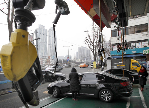 <YONHAP PHOTO-1409> 주유소 휘발유 고공 행진 (서울=연합뉴스) 이상학 기자 = 국제 휘발유 가격이 배럴당 130달러를 넘는 등 국제유가가 급등세를 보이고 있다. 사진은 24일 서울시내 한 주유소. 2012.2.24 leesh@yna.co.kr/2012-02-24 16:32:39/ <저작권자 ⓒ 1980-2012 ㈜연합뉴스. 무단 전재 재배포 금지.>
A motorist visits a gas station in Seoul on Friday.  Yonhap News