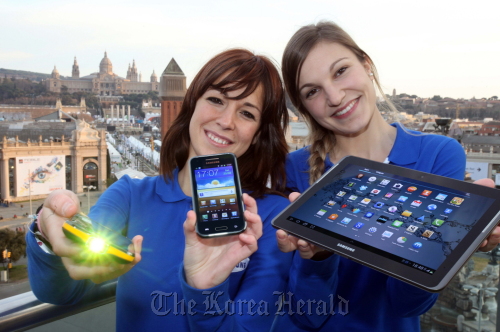 Models hold Samsung Electronics’ Galaxy Beam and Galaxy Tab II.   Samsung Electronics
Models hold Samsung Electronics’ Galaxy Beam and Galaxy Tab II.   Samsung Electronics
