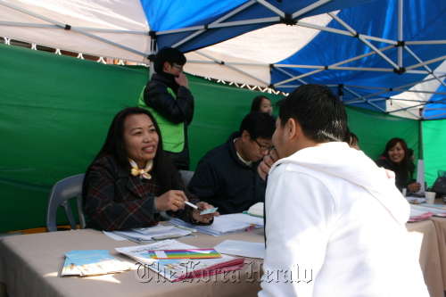 Elena Delacruz, a Filipino consultant for the Seoul Global Center, gives advice to a Filipino worker in the onsite counseling session for Filipino migrants in Seoul on Sunday.   Lee Woo-young/The Korea Herald