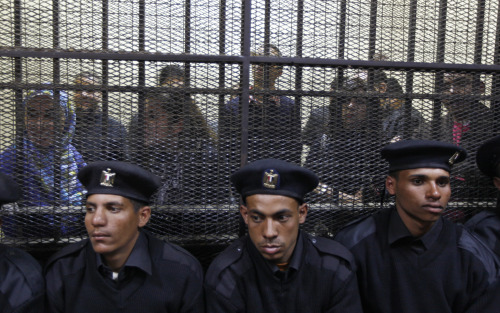 <YONHAP PHOTO-0328> Egyptian policemen sit in front of Egyptian employees of several pro-democracy groups charged with using foreign funds to foment unrest during their trial in Cairo, Egypt, Sunday, Feb. 26, 2012. Egypt went forward with a trial Sunday that has plunged relations with the U.S. into the deepest crisis in decades, prosecuting 16 Americans and 27 other employees of pro-democracy groups. (AP Photo/Khalil Hamra)/2012-02-27 06:17:23/ <저작권자 ⓒ 1980-2012 ㈜연합뉴스. 무단 전재 재배포 금지.>
Egyptian policemen sit in front of Egyptian employees of several pro-democracy groups charged with using foreign funds to foment unrest during their trial in Cairo on Sunday.  AP-Yonhap News