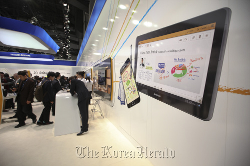 An illuminated image of a Samsung Electronics Co. tablet and Galaxy smartphones are seen on display at the company`s booth at the Mobile World Congress in Barcelona, Spain, Tuesday. (Bloomberg)