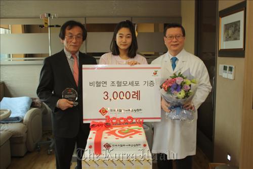 The nation’s 3,000th bone marrow donor Kim Ji-in (center) poses for a photo with Hwang Tai-ju (left), president of Korea Marrow Donor Program, and Lee Hong-ki, a hematology doctor at Konkuk University Medical Center.  Yonhap News