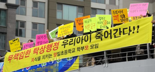 개학시즌인 5일 오전 경기도 일산동구 식사동에 위치한 양일초등학교에 때 아닌 등교거부운동이 일어나고 있다. 이 학교의 '자식을 지키는 양일초등학교 학부모 모임'의 회원들이 인근 단지를 돌며 폐차장의 매연으로 인한 학교의 이전을 요구하는 집회를 가지고 있다. 박해묵 기자/mook@heraldm.com\r\n5일 기다리던 개학이다. 그러나 학생들이 ‘등교거부’를 하고 있다. 무슨 일일까. 경기도 일산 동구 식사동에 위치한 양일초등학교. 이 학교 주변에 폐건축물 처리장이 있다. 학부모들은 처리장 매연으로 아이들의 건강에 심각한 영향을 미칠 수 있다고 주장한다. ‘자식을 지키는 양일초등학교 학부모모임’의 회원들이 등교거부까지 하며 처리장 이전 을 요구하는 시위를 벌이고 있다.  박해묵 기자/mook@heraldm.com
