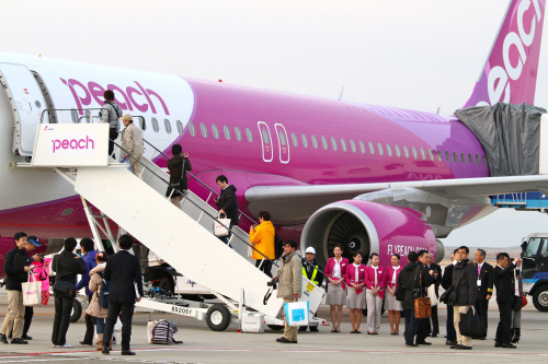 Passengers board an Airbus SAS A320 airplane for a Peach Aviation Ltd. flight at Kansai International Airport in Izumisano City, Osaka, Japan on Thursday, March 1, 2012. Peach Aviation Ltd., backed by All Nippon Airways Co., begins flights in Japan today, becoming the first of three budget carriers to start operations in the country this year. Photographer: Tetsuya Yamada/Bloomberg
Passengers board an Airbus SAS A320 airplane for a Peach Aviation Ltd. flight at Kansai International Airport in Izumisano City, Osaka.  Bloomberg