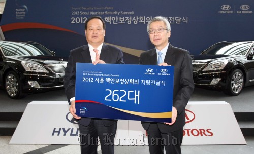 Hyundai Motor president Kim Choong-ho (left) poses after delivering protocol vehicles to the preparation committee for the 2012 Nuclear Security Summit at the COEX in southern Seoul on Monday. Hyundai Motor