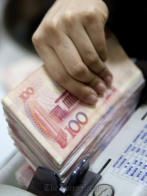 A clerk at a branch of the Bank of China Ltd. counts 100 yuan notes in Beijing.  Bloomberg