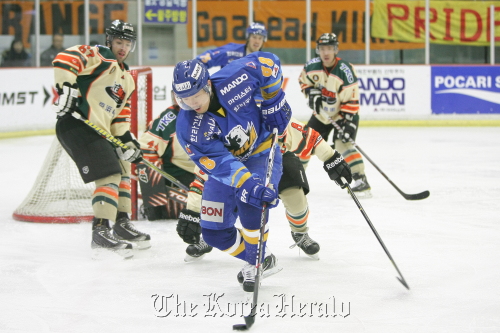 Anyang Halla’s Kim Geun-ho controls the puck in front of Icebucks defenders during Game 3 of the Asia League hockey playoffs at Anyang Ice Rink on Tuesday.  Anyang Halla
